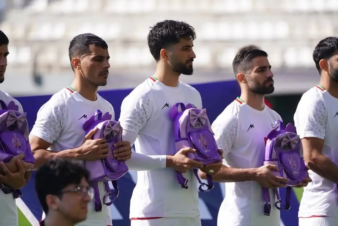 Iran national team players carry school bags before friendly against Nigeria in tribute to schoolgirls killed in Minaab