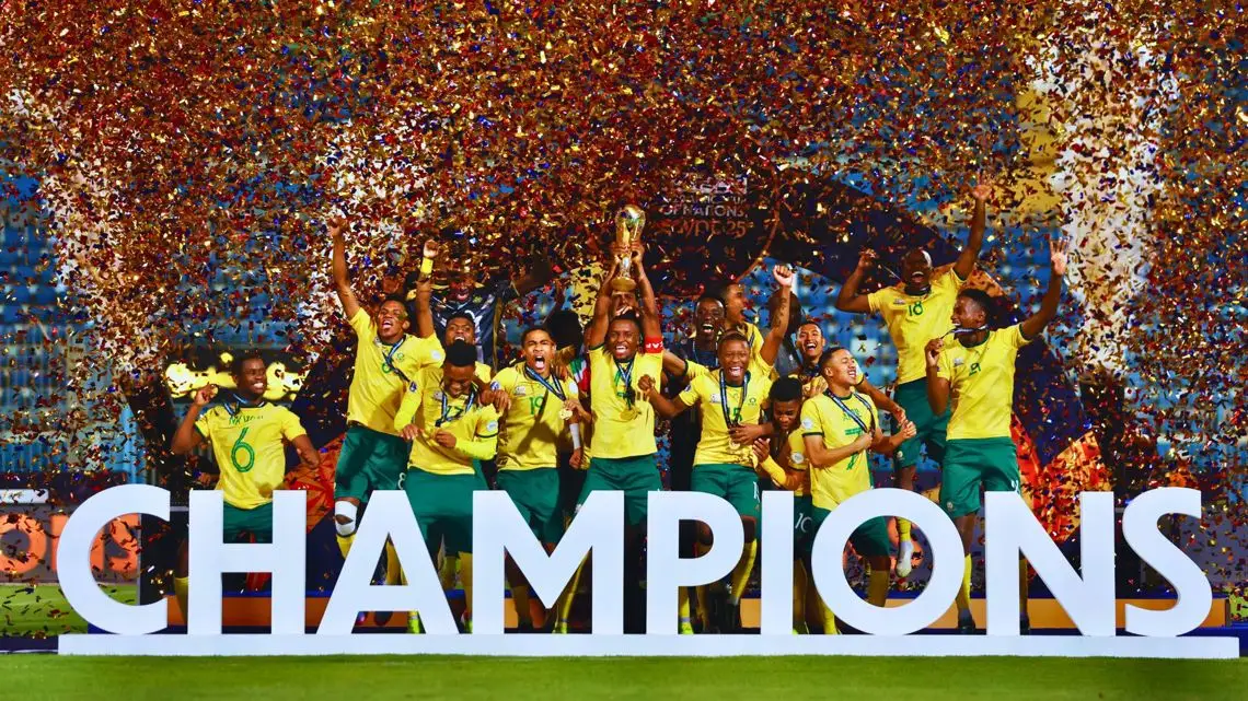 Brazilian soccer team celebrating on a podium with a large 'CHAMPIONS' sign and confetti raining down.