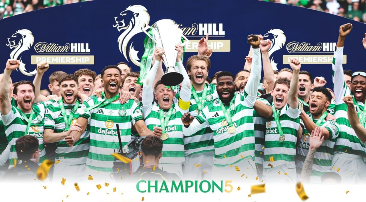 Celtic players celebrate winning the league title, lifting the trophy with medals during a trophy ceremony.