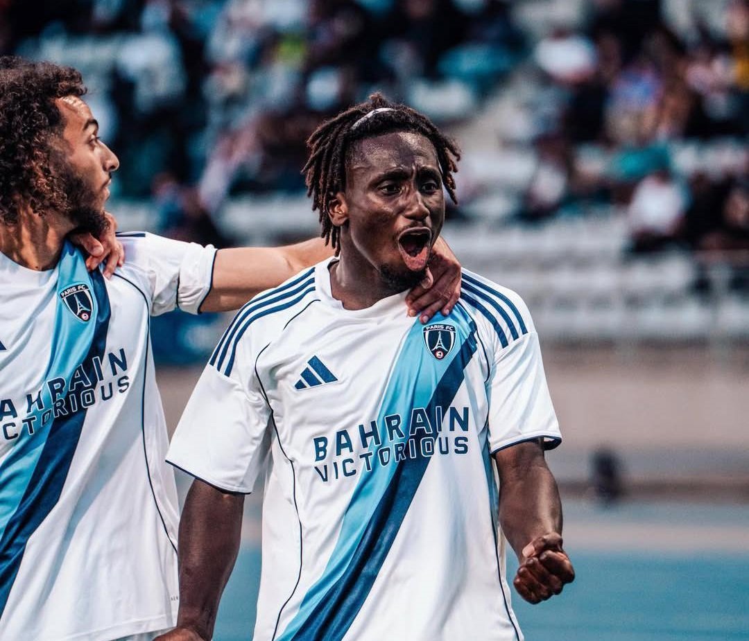 Two soccer players in white and blue jerseys celebrate on the field, one shouting with arm around his teammate's shoulders. Two soccer players in white and blue jerseys celebrate on the field, one shouting with arm around his teammate's shoulders.