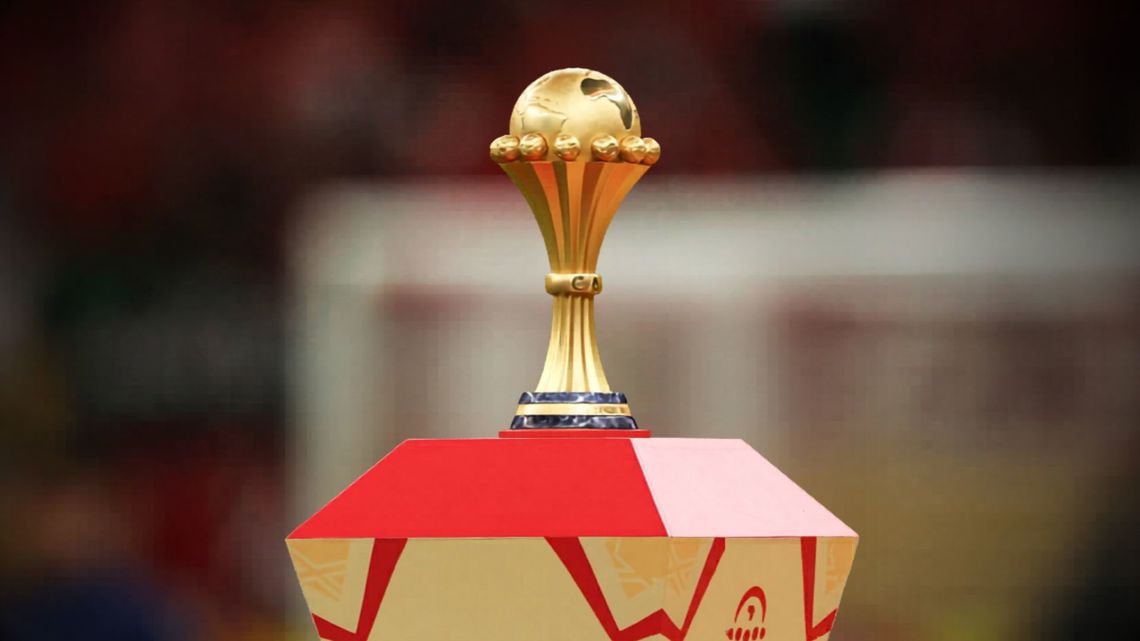 Gold trophy with a globe on top, resting on a red and cream pedestal.