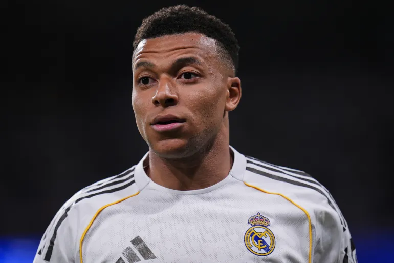 Close-up of a male soccer player wearing a Real Madrid jersey, looking to the left with a focused expression that suggests play underway. Close-up of a male soccer player wearing a Real Madrid jersey, looking to the left with a focused expression that suggests play underway.