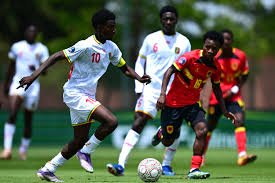 Soccer players in white and red jerseys chase the ball on a green field; foreground shows a white-jersey #10 and a red/yellow-jersey opponent competing for the ball. Soccer players in white and red jerseys chase the ball on a green field; foreground shows a white-jersey #10 and a red/yellow-jersey opponent competing for the ball.