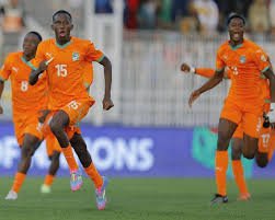 Soccer players in orange jerseys celebrate on the field, running with joy after a likely goal. Soccer players in orange jerseys celebrate on the field, running with joy after a likely goal.