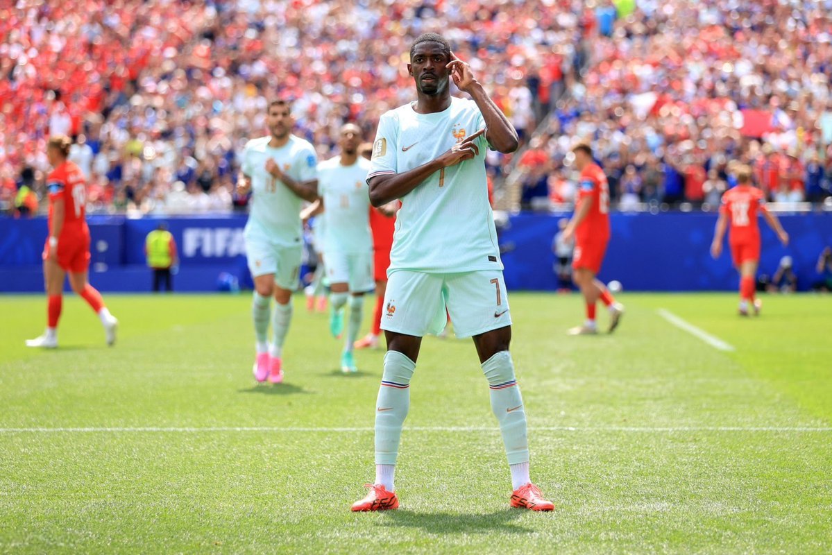Soccer player in light blue France kit waves to the crowd on a crowded stadium field. Soccer player in light blue France kit waves to the crowd on a crowded stadium field.