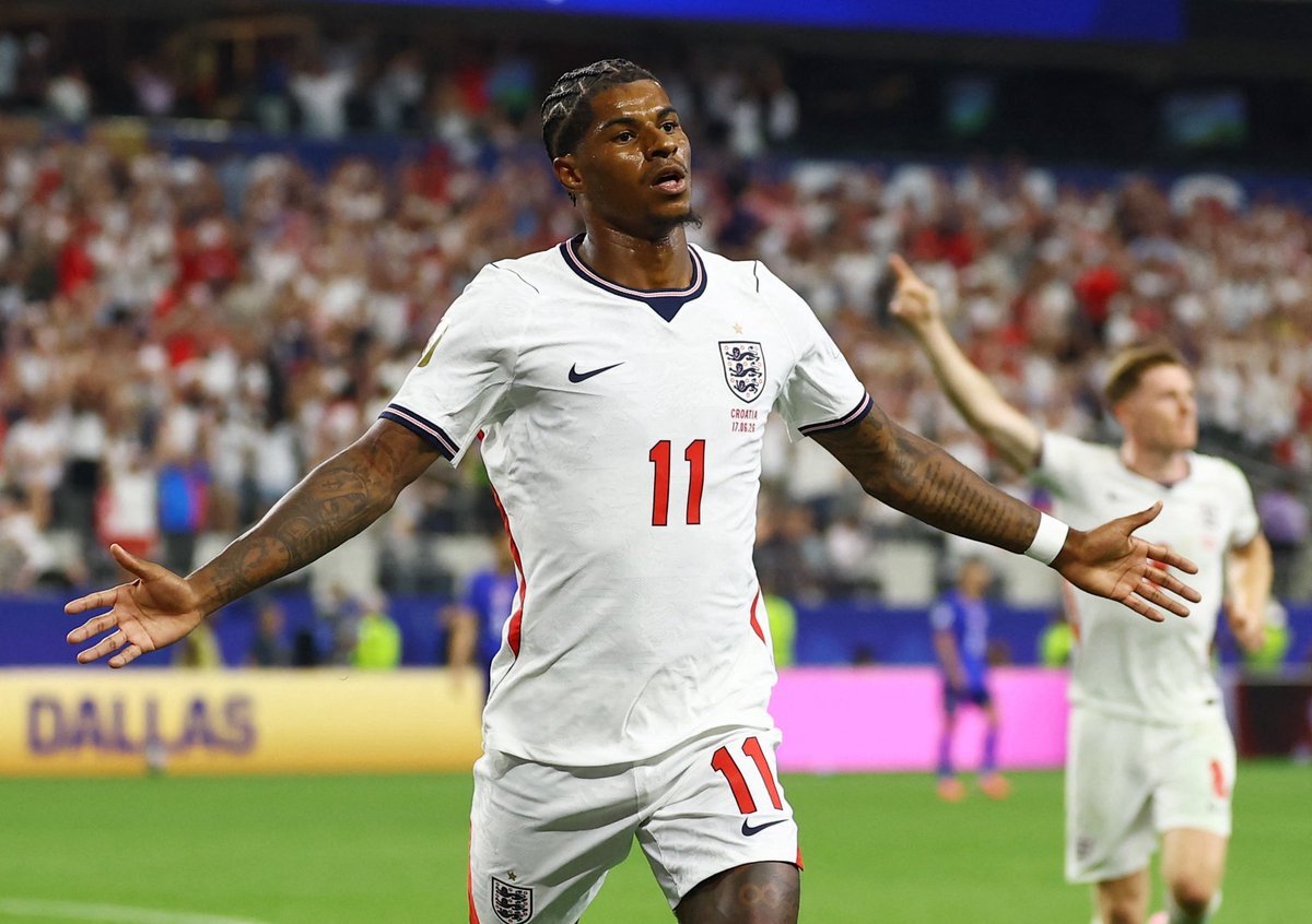 English footballer in white England kit with number 11 celebrates with arms outstretched on the pitch, crowd cheering in the stands English footballer in white England kit with number 11 celebrates with arms outstretched on the pitch, crowd cheering in the stands