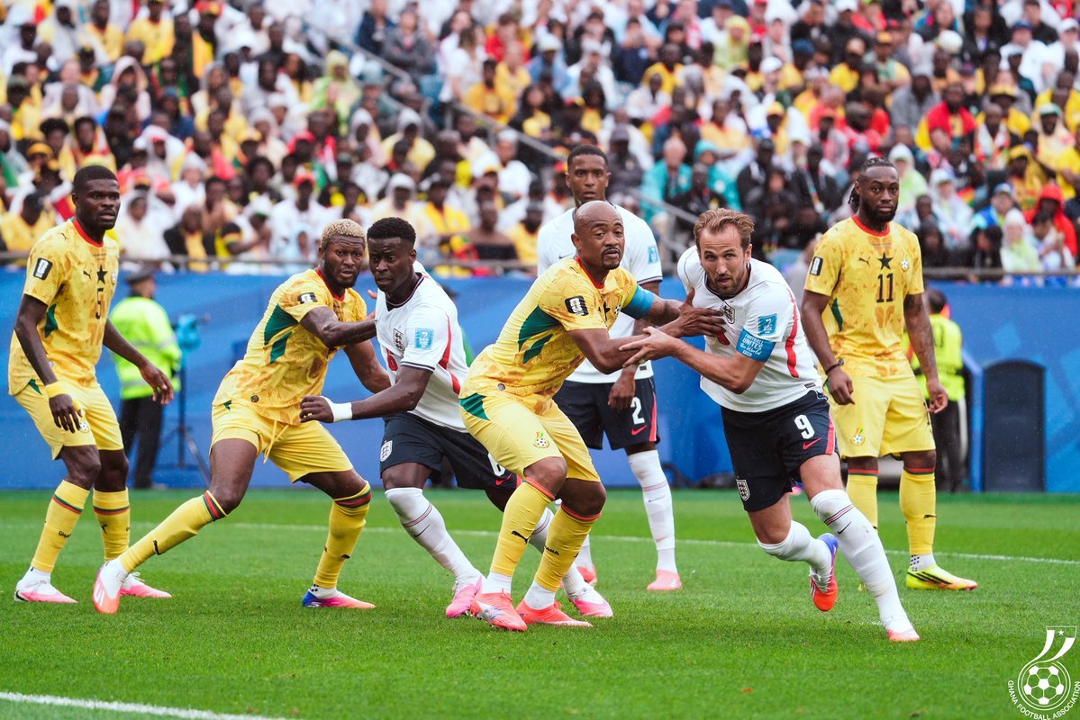 Soccer players in yellow and white jerseys contest the ball on a lush green field with a crowded stadium in the background. Soccer players in yellow and white jerseys contest the ball on a lush green field with a crowded stadium in the background.