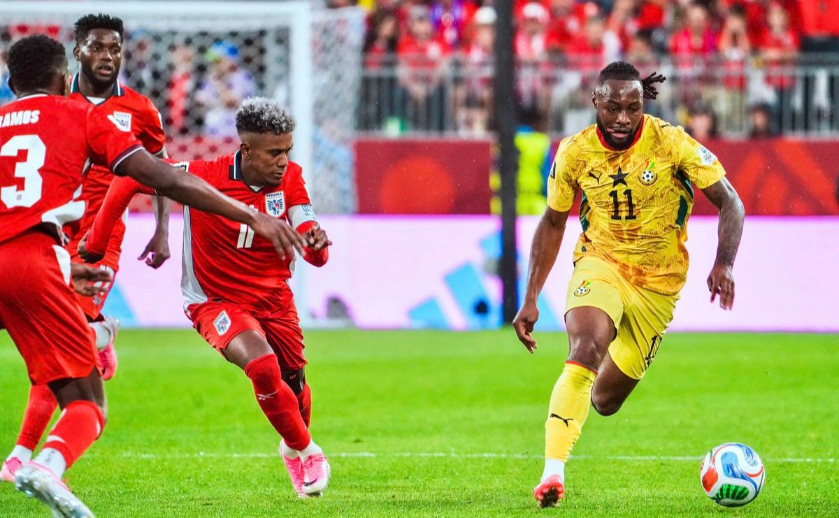 Soccer player in yellow with number 11 dribbles the ball toward the goal as red-clad opponents close in on him. Soccer player in yellow with number 11 dribbles the ball toward the goal as red-clad opponents close in on him.
