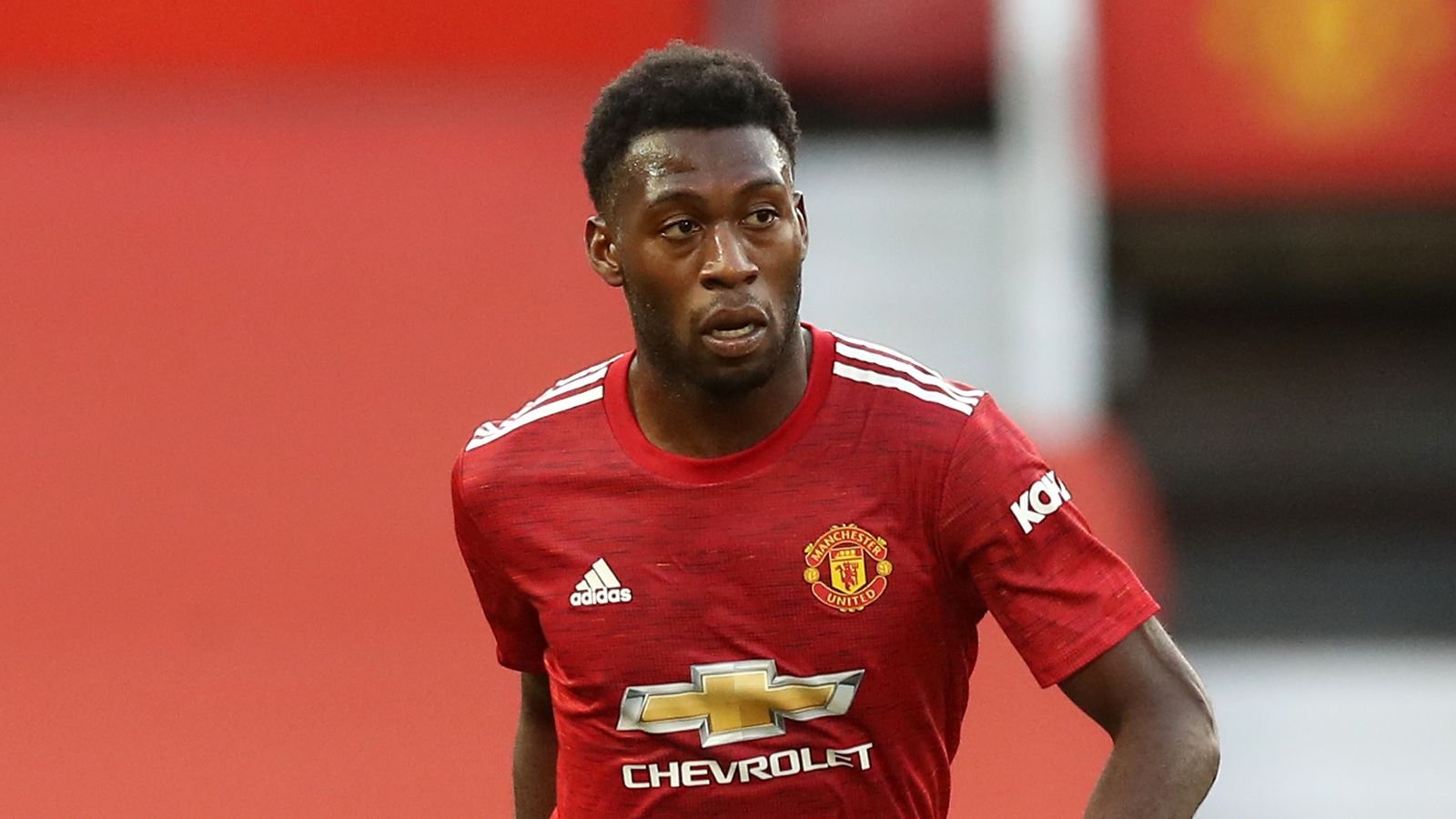 Manchester United footballer in red training kit running on the pitch during a match or training