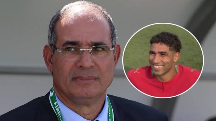 Man in a suit and glasses with a green lanyard; circular inset shows a smiling footballer in a red jersey on a field Man in a suit and glasses with a green lanyard; circular inset shows a smiling footballer in a red jersey on a field