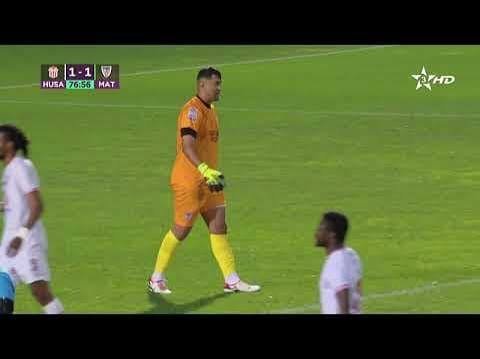 Soccer goalkeeper in an orange kit and bright yellow socks walking on a green pitch during a 1-1 match. Soccer goalkeeper in an orange kit and bright yellow socks walking on a green pitch during a 1-1 match.