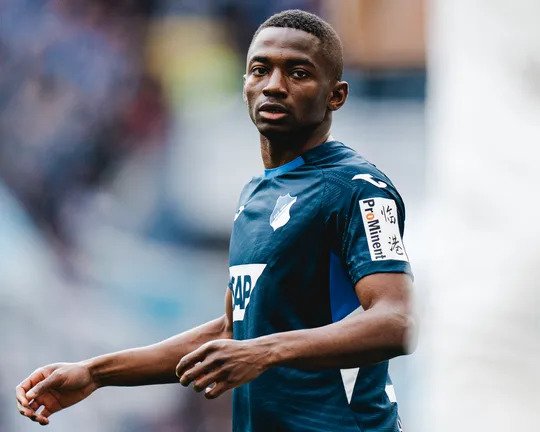 Male soccer player in a blue jersey with SAP logo on the chest, on the field and looking toward the camera.