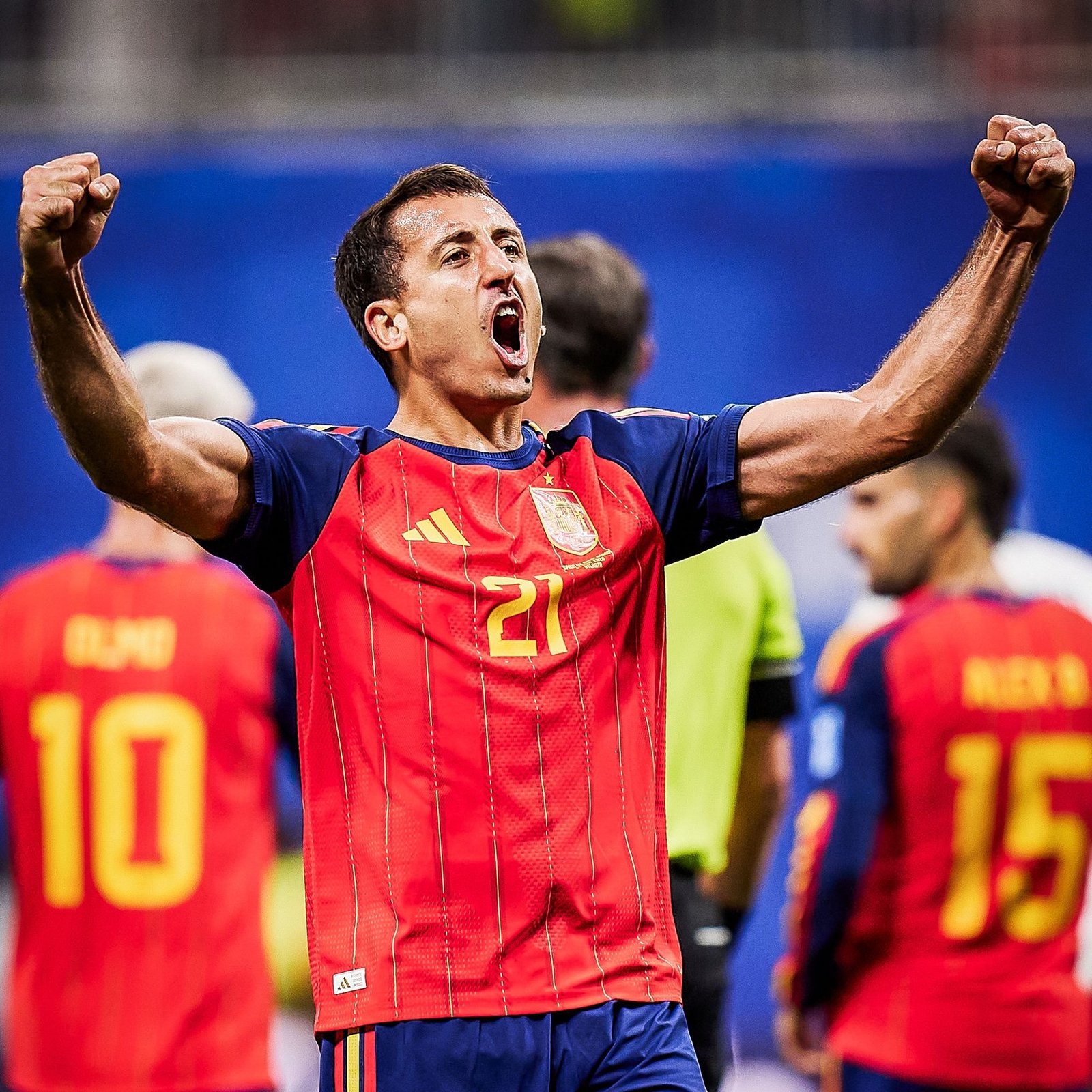 Soccer player in a red jersey with arms raised in celebration, number 21 visible on the shirt. Soccer player in a red jersey with arms raised in celebration, number 21 visible on the shirt.