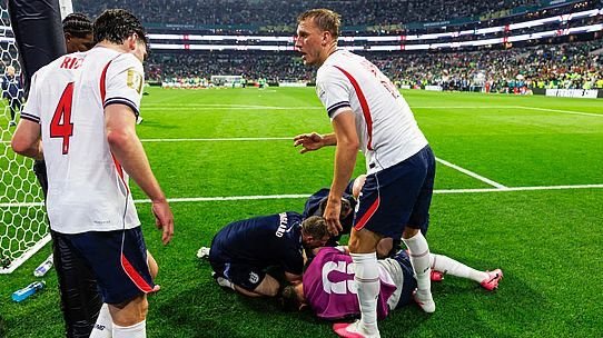 Soccer players surround an injured goalkeeper on the grass near the goal after a collision during a match. Soccer players surround an injured goalkeeper on the grass near the goal after a collision during a match.