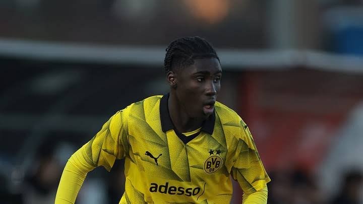 Soccer player wearing a yellow Borussia Dortmund jersey runs on the field during a match. Soccer player wearing a yellow Borussia Dortmund jersey runs on the field during a match.