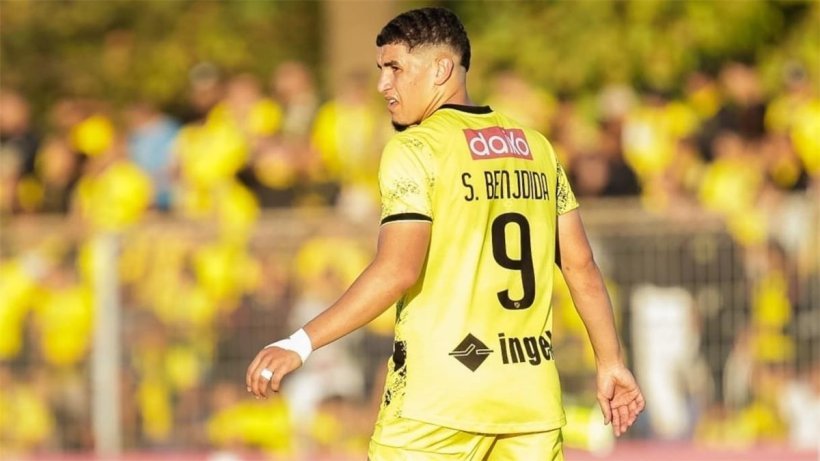 Soccer player in a yellow jersey with the number 9 on the back, seen from behind on the field." Soccer player in a yellow jersey with the number 9 on the back, seen from behind on the field."