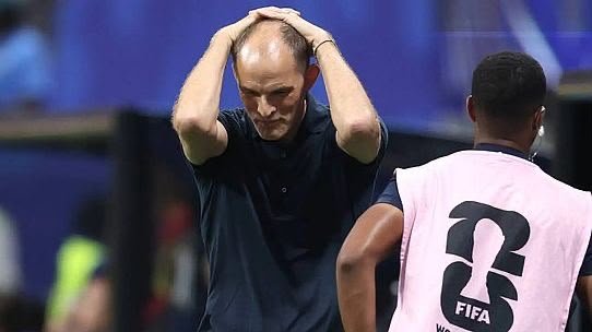 Frustrated football coach holds his head in disbelief on the sideline during a match, with a player wearing a pink bib nearby. Frustrated football coach holds his head in disbelief on the sideline during a match, with a player wearing a pink bib nearby.
