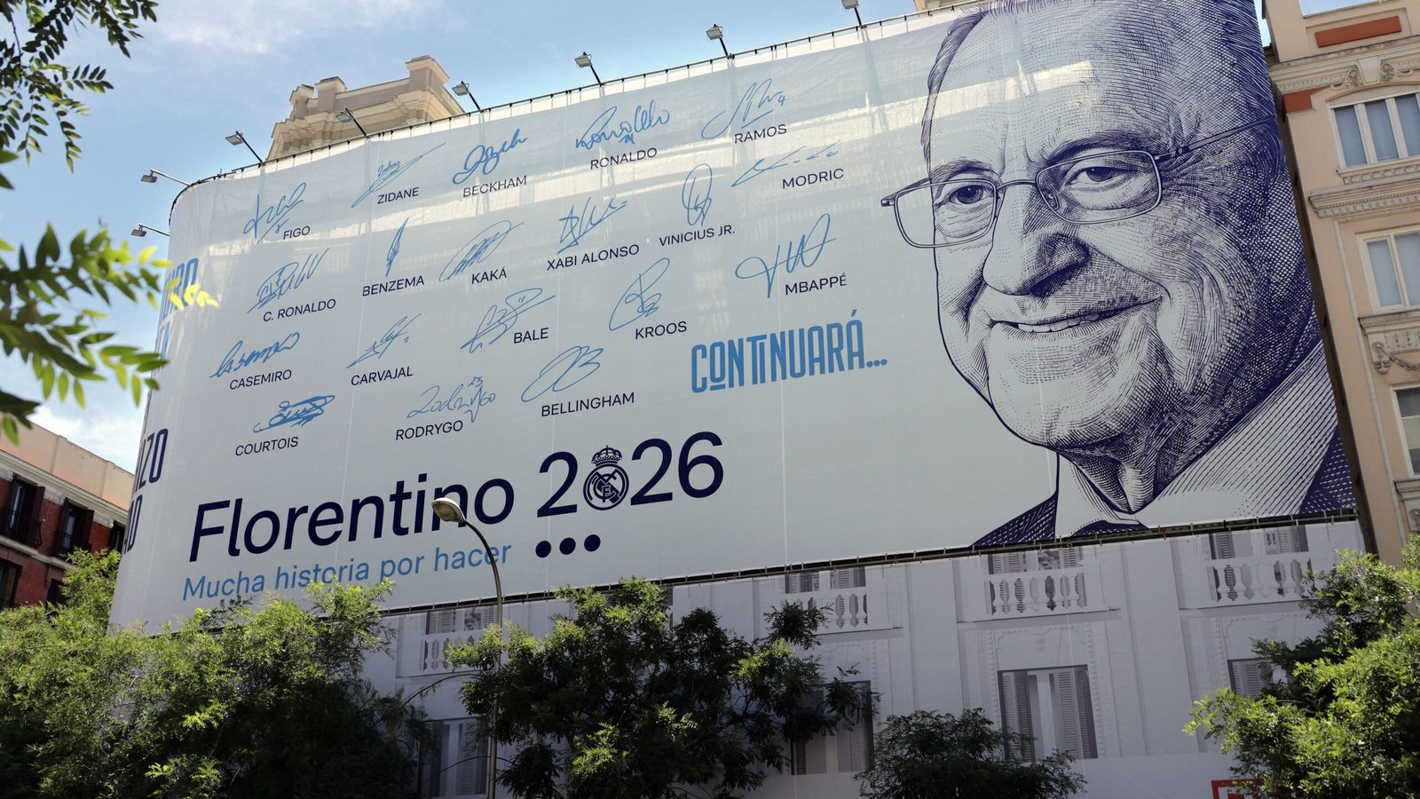 Large billboard featuring numerous blue signatures, a detailed portrait, and the text 'Florentino 2026' and 'CONTINUARÁ...' on the right edge.