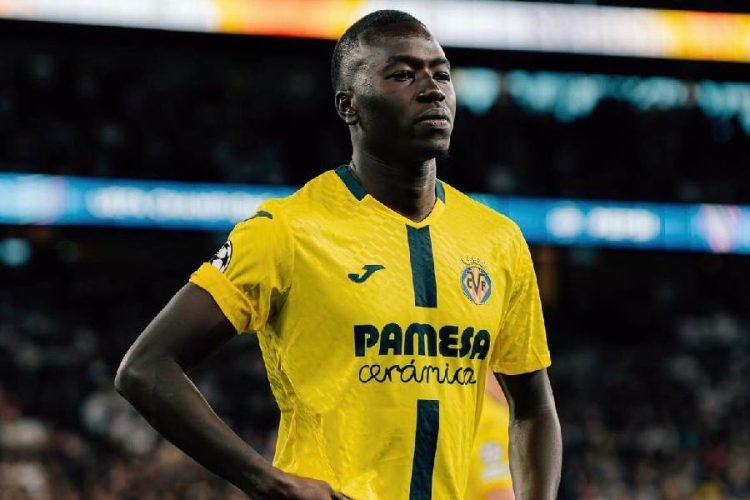 Soccer player in a yellow Villarreal CF jersey standing on the pitch with hands on hips, stadium in background. Soccer player in a yellow Villarreal CF jersey standing on the pitch with hands on hips, stadium in background.