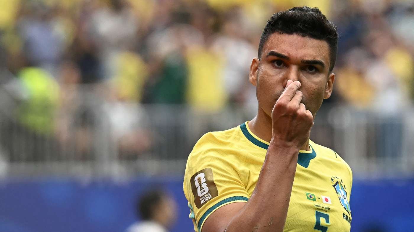 Brazilian footballer in a yellow Brazil kit pinching his nose with his right hand during a match, crowd blurred in the background, front view Brazilian footballer in a yellow Brazil kit pinching his nose with his right hand during a match, crowd blurred in the background, front view