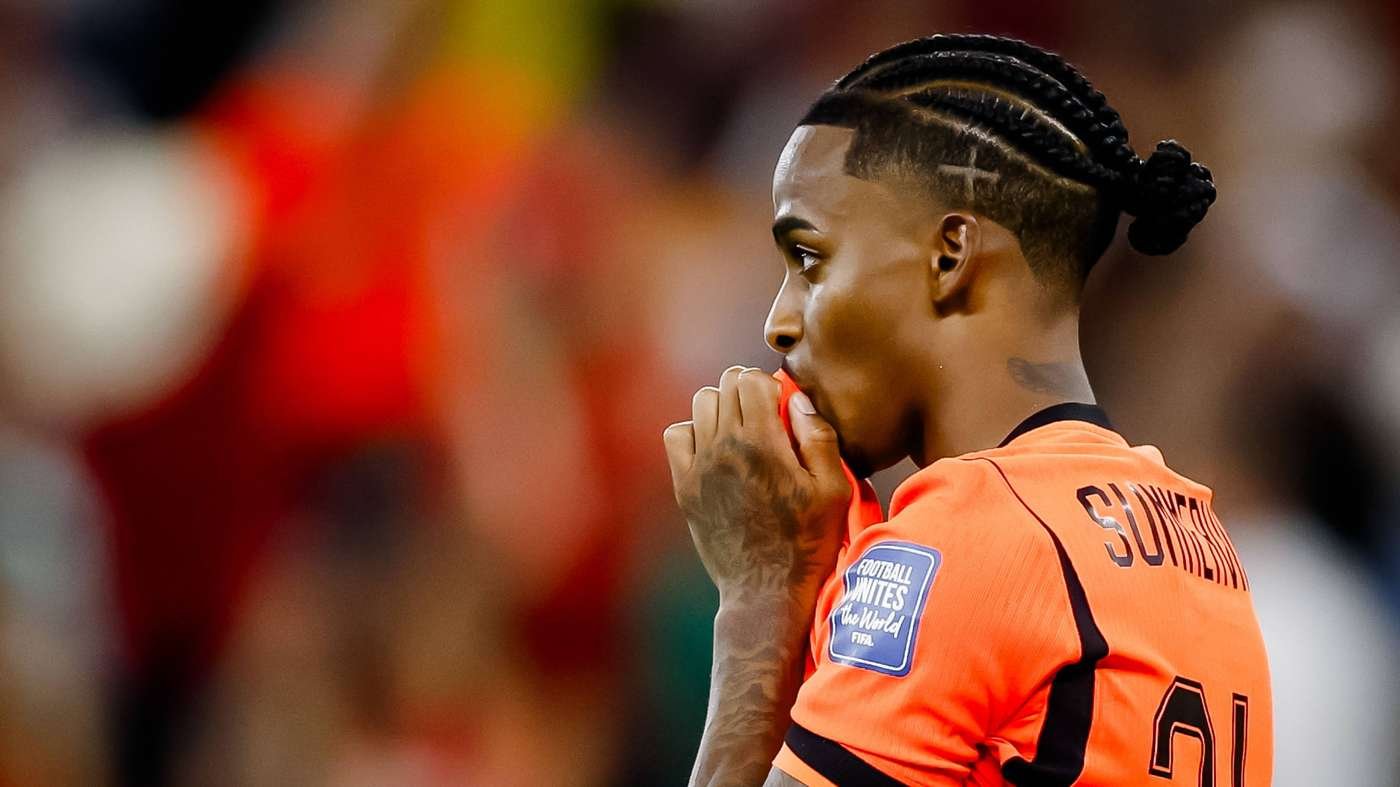 Soccer player in an orange jersey biting the collar, seen from side with cornrowed hair and number 21 on the back. Soccer player in an orange jersey biting the collar, seen from side with cornrowed hair and number 21 on the back.