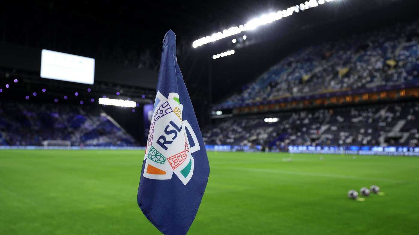 Blue corner flag with RSL logo on a soccer field at night stadium, focus on flag with blurred stands in background Blue corner flag with RSL logo on a soccer field at night stadium, focus on flag with blurred stands in background