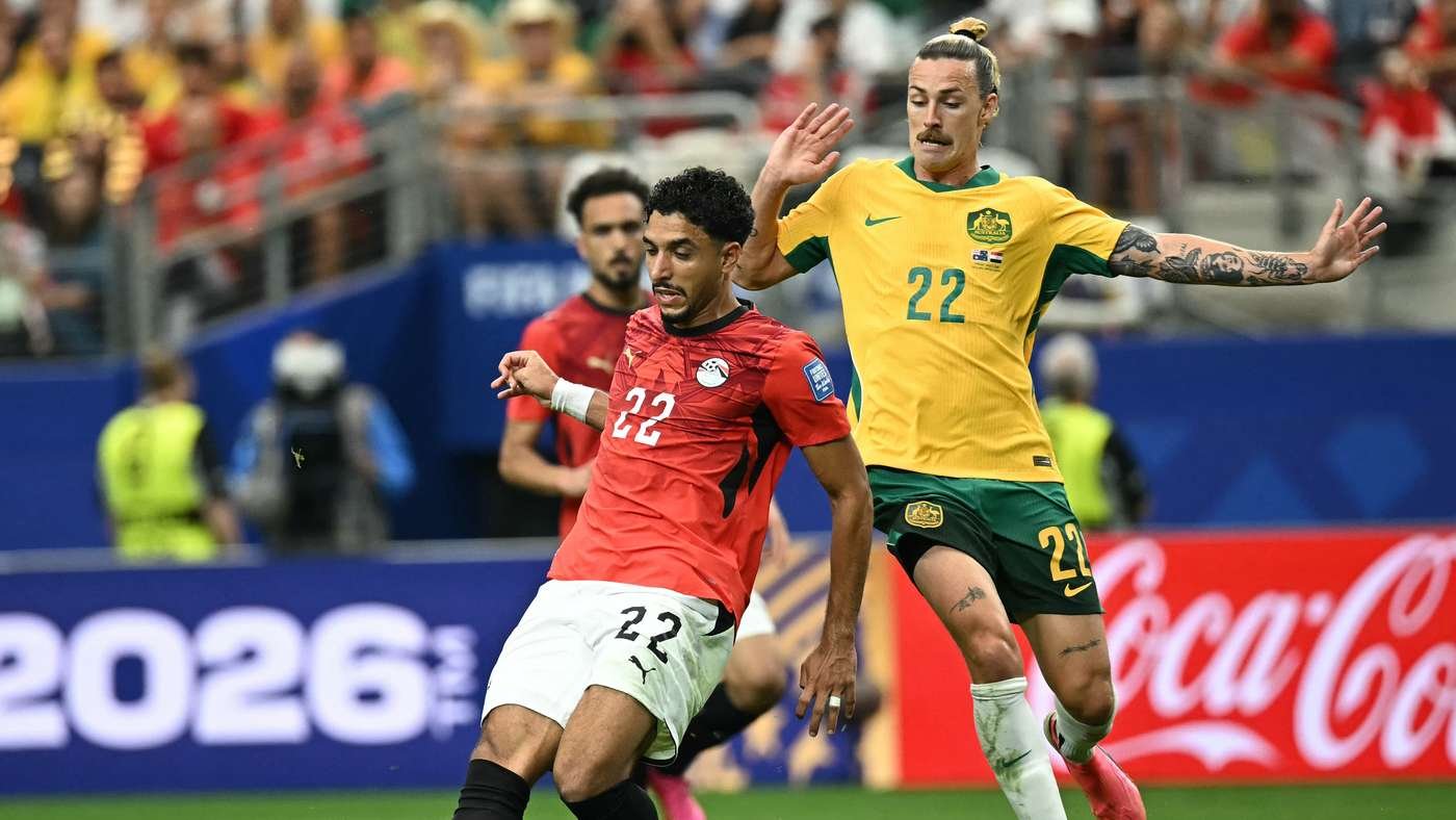 Two soccer players contesting the ball during a match, one in red (No. 22) and one in yellow (No. 22) with a Coca‑Cola ad behind them. Two soccer players contesting the ball during a match, one in red (No. 22) and one in yellow (No. 22) with a Coca‑Cola ad behind them.