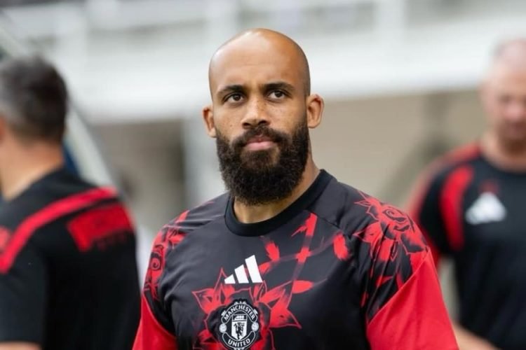 Man with shaved head and full beard wearing a Manchester United training jersey during practice. Man with shaved head and full beard wearing a Manchester United training jersey during practice.