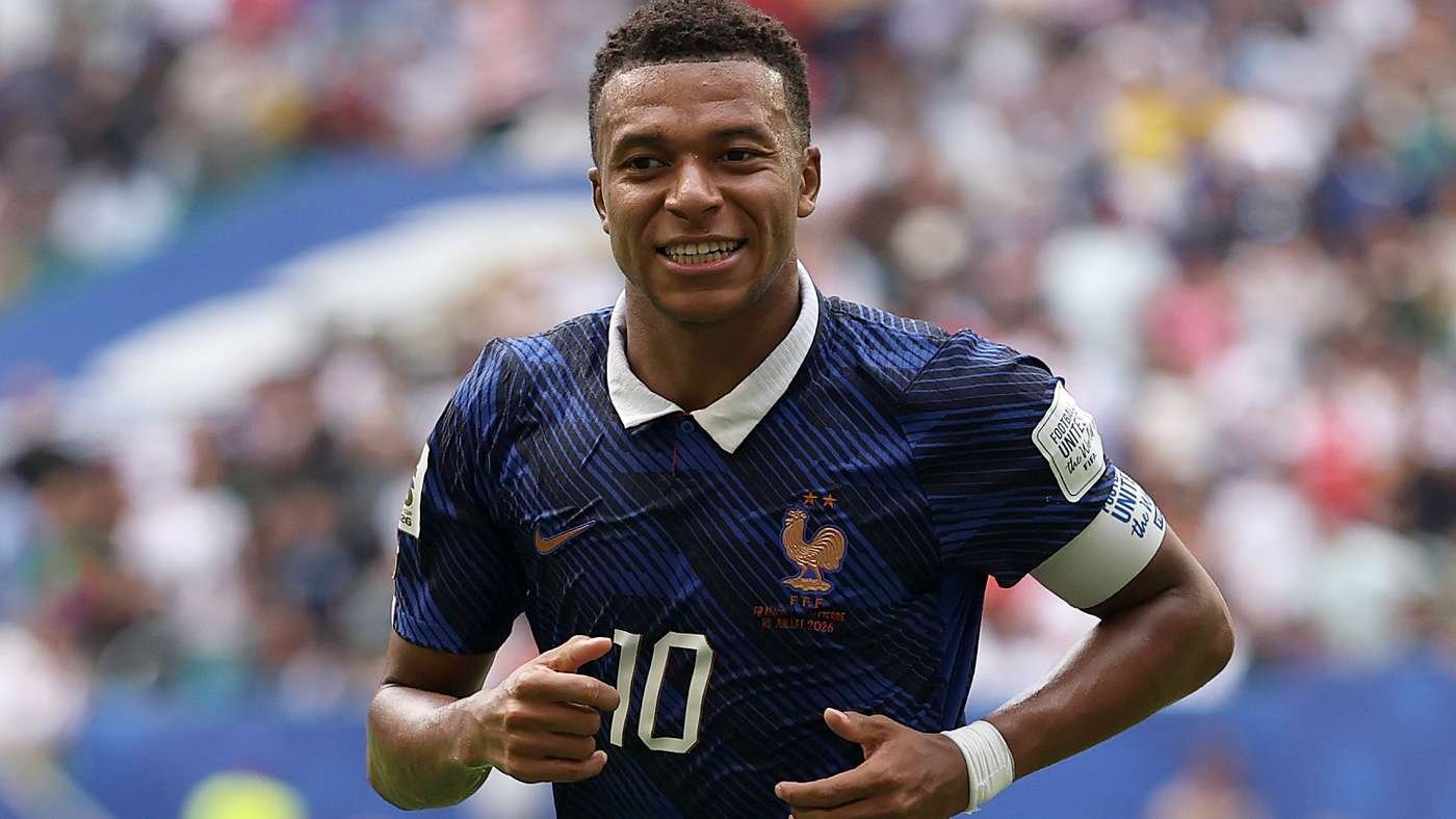 French national team soccer player wearing a blue jersey with number 10 and a captain's armband, running on the field with a stadium crowd behind him. French national team soccer player wearing a blue jersey with number 10 and a captain's armband, running on the field with a stadium crowd behind him.