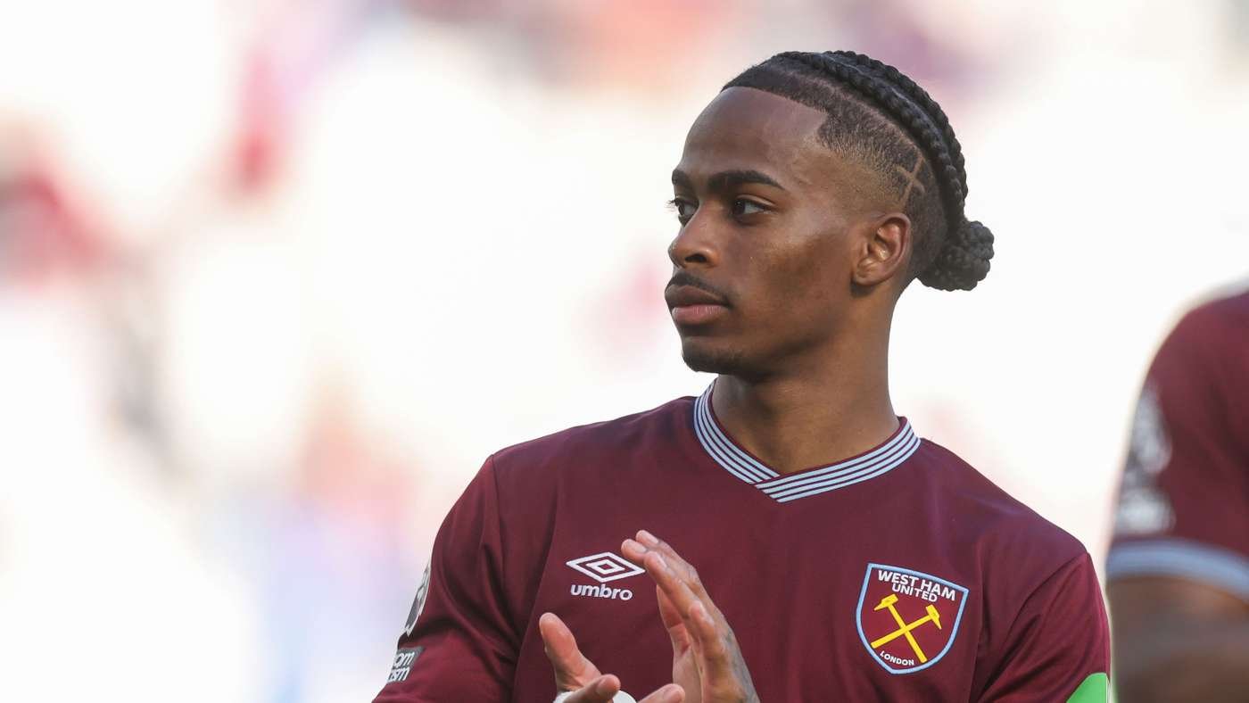 West Ham player with cornrowed hair in maroon jersey, looking to the side during a match.