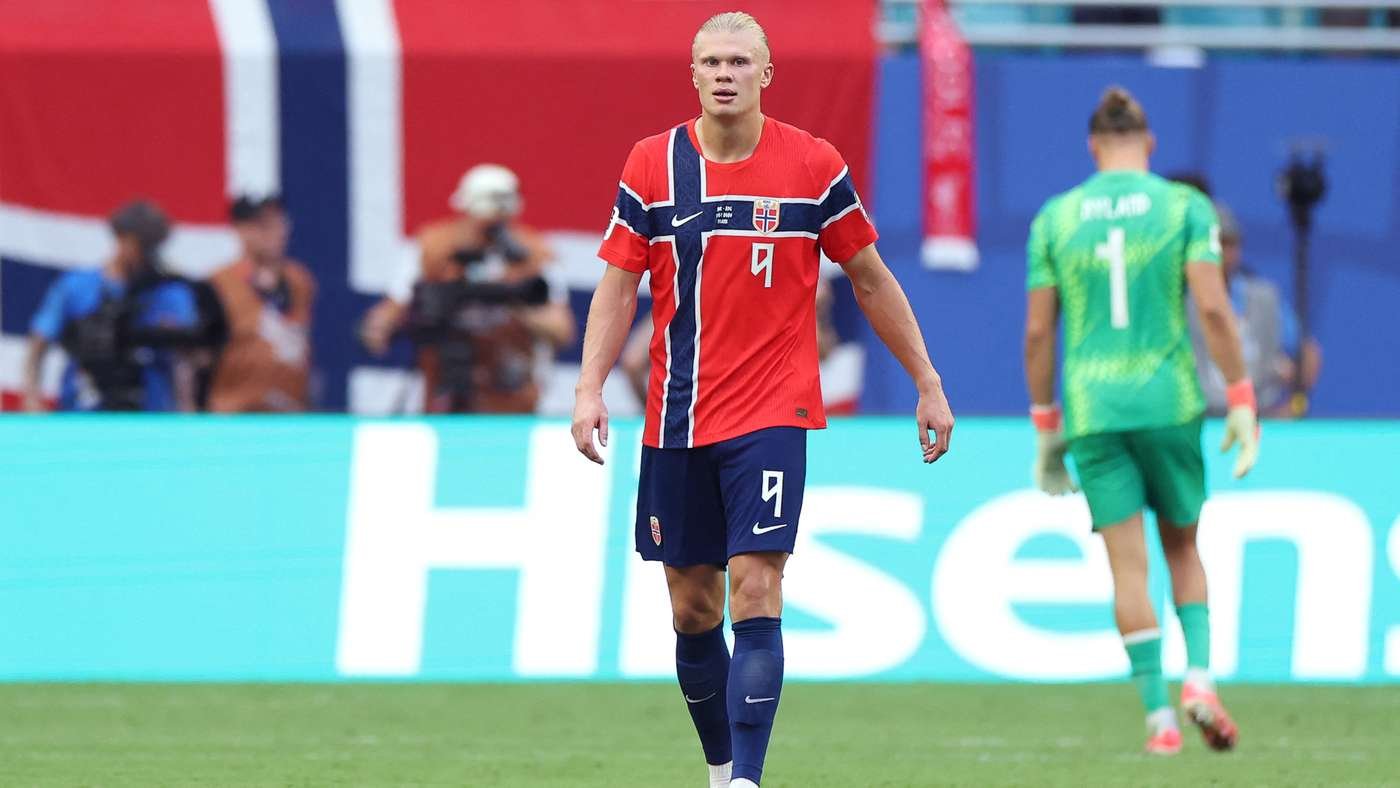 Norway national team footballer in red jersey with blue cross, number 9, walking on the pitch during a match.