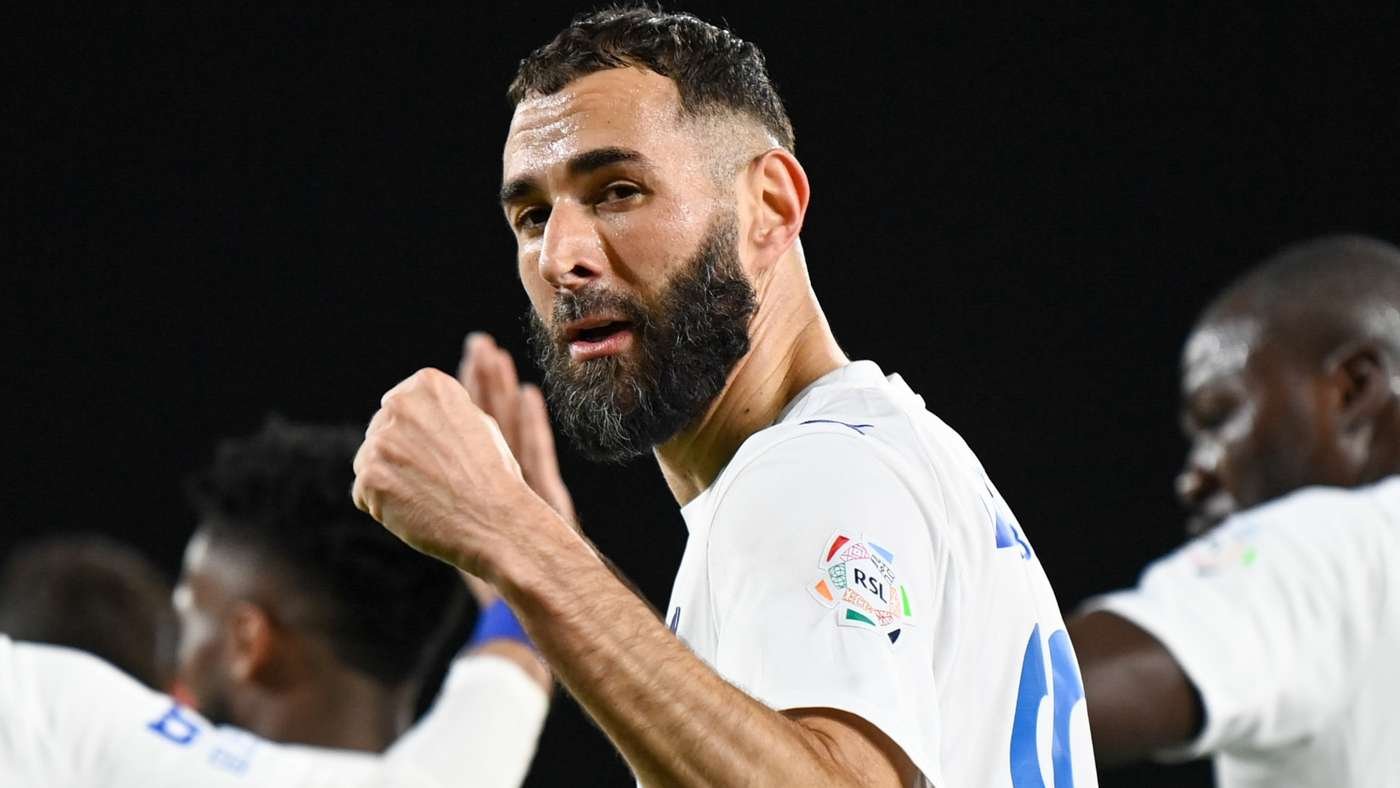 Bearded soccer player in a white jersey raises his fist in celebration during a match, night game setting. Bearded soccer player in a white jersey raises his fist in celebration during a match, night game setting.