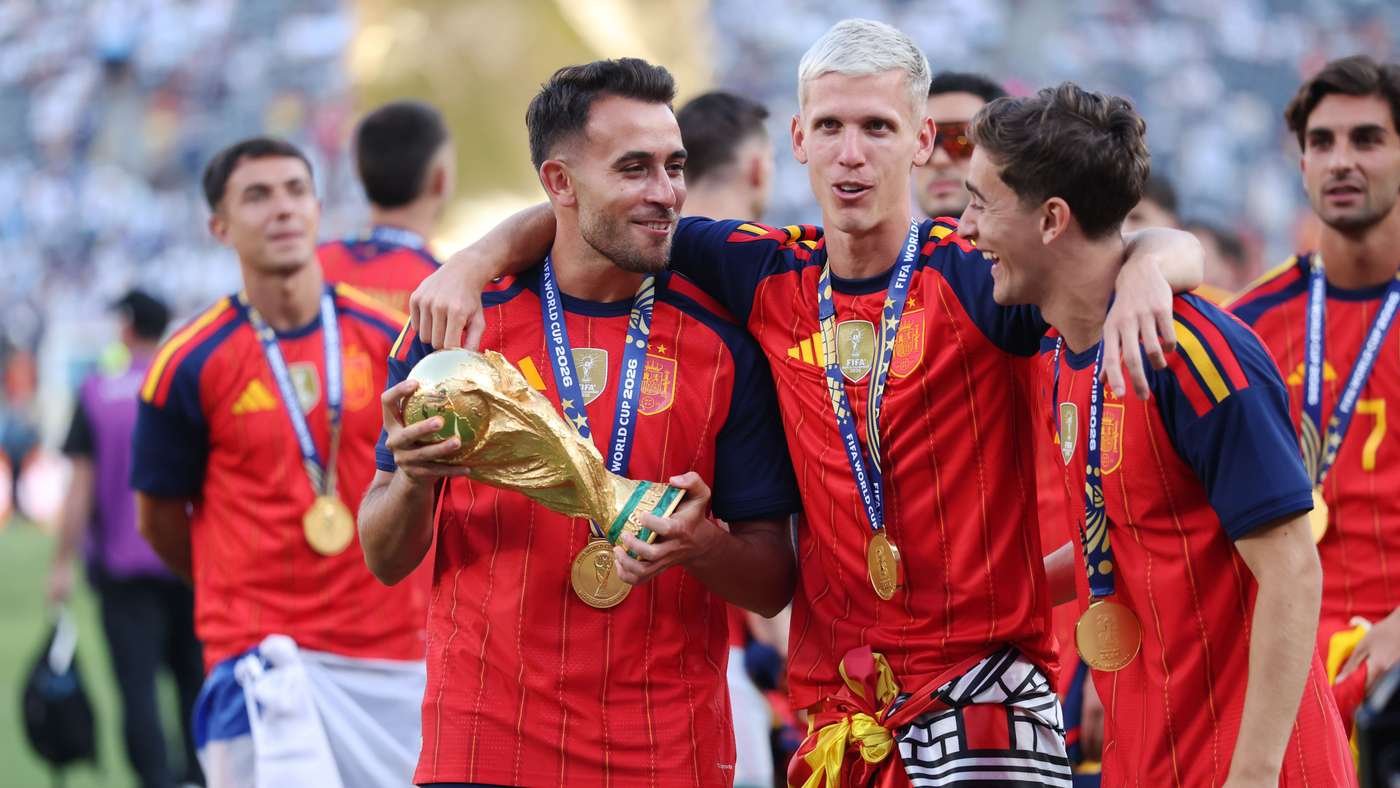 Spain football team players celebrate with gold medals and the World Cup trophy on the field, hugging after victory. Spain football team players celebrate with gold medals and the World Cup trophy on the field, hugging after victory.