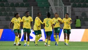 Soccer team in yellow jerseys walking across a green field after a match in a stadium with empty stands. Soccer team in yellow jerseys walking across a green field after a match in a stadium with empty stands.
