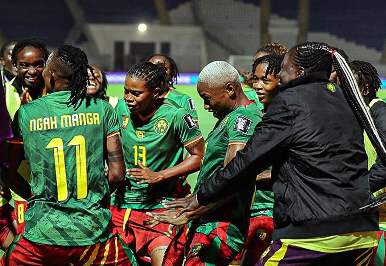 Soccer players in green jerseys celebrate together on the field, one with 'NGAH MANGA' and number 11 on his back. Soccer players in green jerseys celebrate together on the field, one with 'NGAH MANGA' and number 11 on his back.
