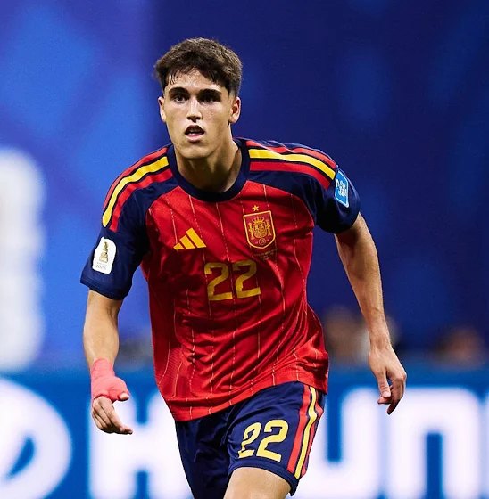 A Spanish footballer in a red jersey with number 22, running on the field with a focused expression.