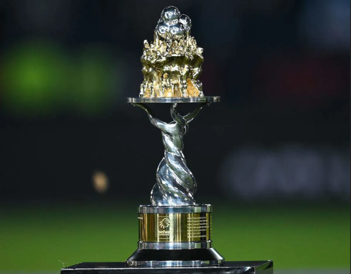 Elegant trophy with a twisted silver stem and a gold sculpted top on a black base, outdoors on grass field.