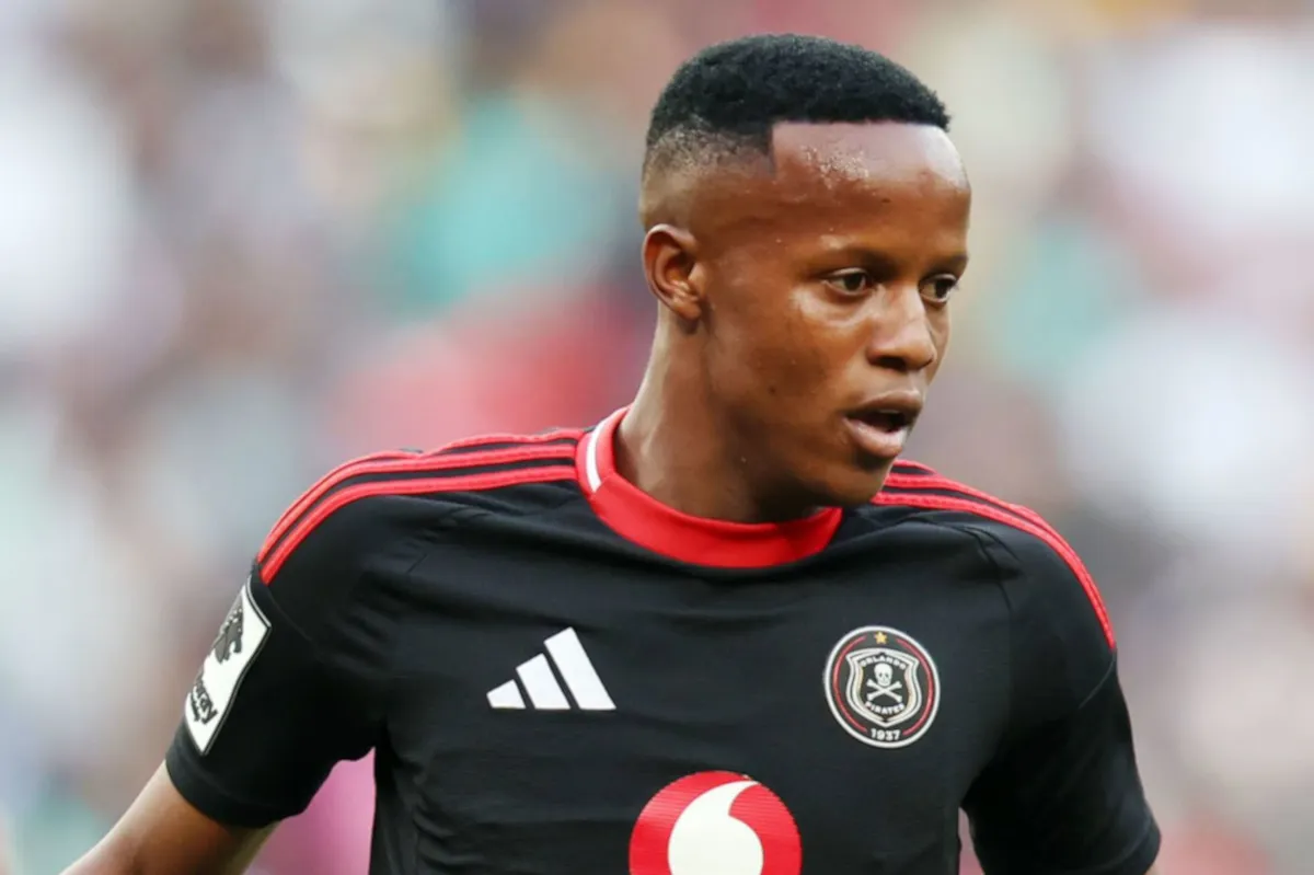 Soccer player in a black jersey with red trim, running on the field during a match with a club crest visible on chest. Soccer player in a black jersey with red trim, running on the field during a match with a club crest visible on chest.