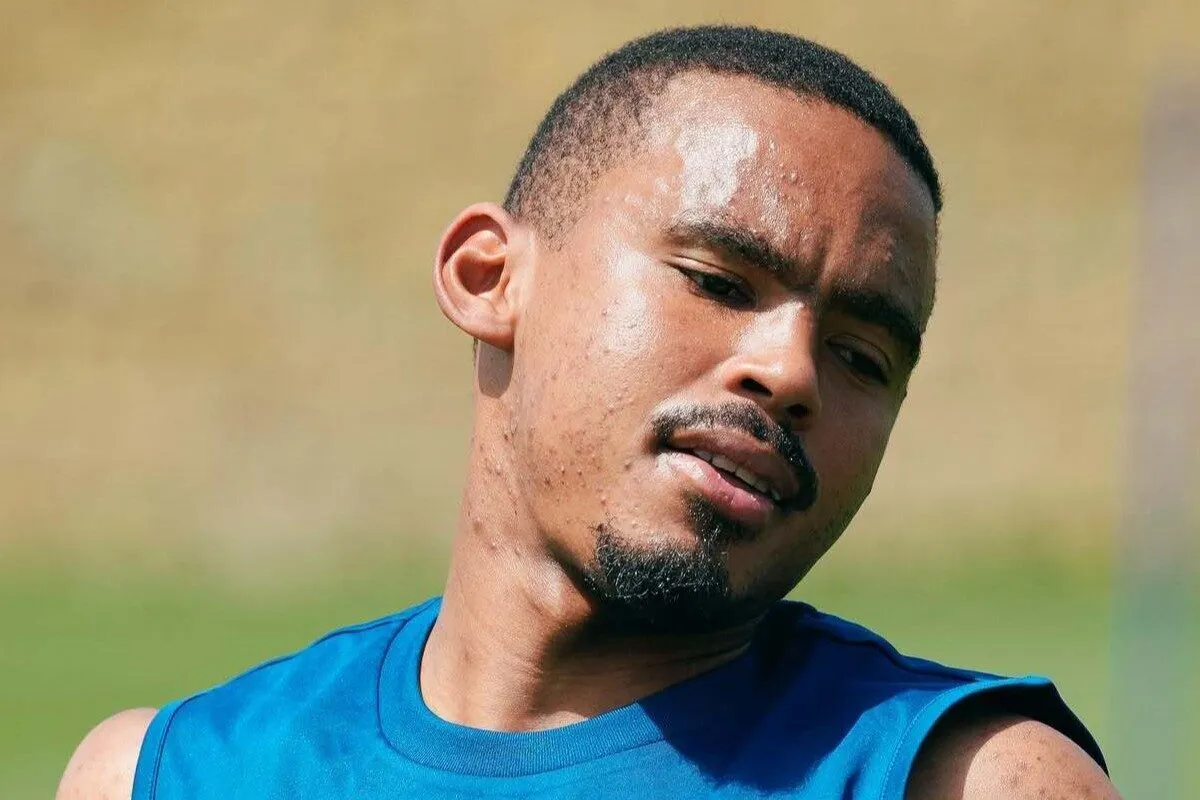 Close-up of a man in a blue sleeveless shirt sweating while looking to the side outdoors. Close-up of a man in a blue sleeveless shirt sweating while looking to the side outdoors.