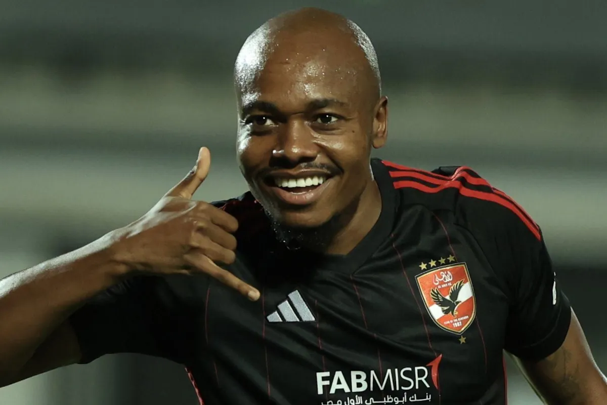 Soccer player in a black jersey celebrating with a shaka gesture and a smile. Soccer player in a black jersey celebrating with a shaka gesture and a smile.