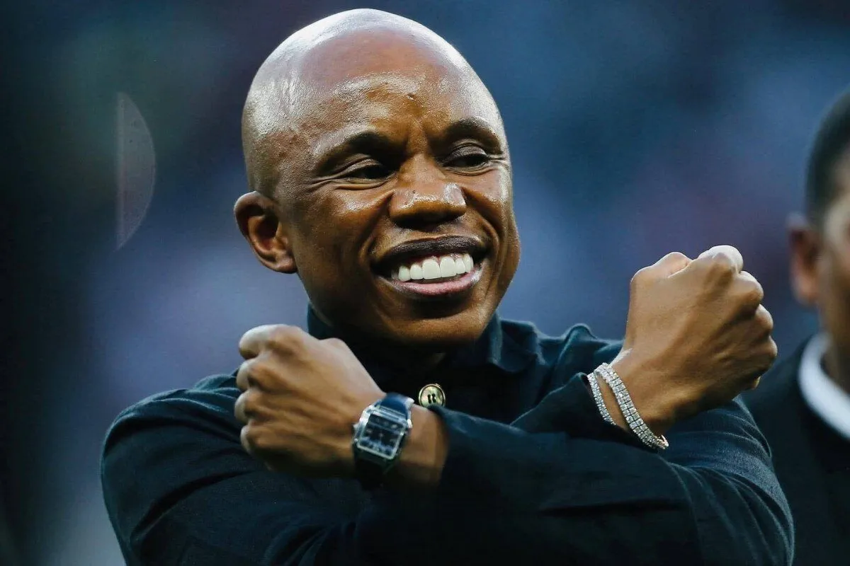 Smiling man with arms crossed in front of his chest, wearing a black shirt, a silver watch on his left wrist and a diamond bracelet on his right wrist. Smiling man with arms crossed in front of his chest, wearing a black shirt, a silver watch on his left wrist and a diamond bracelet on his right wrist.