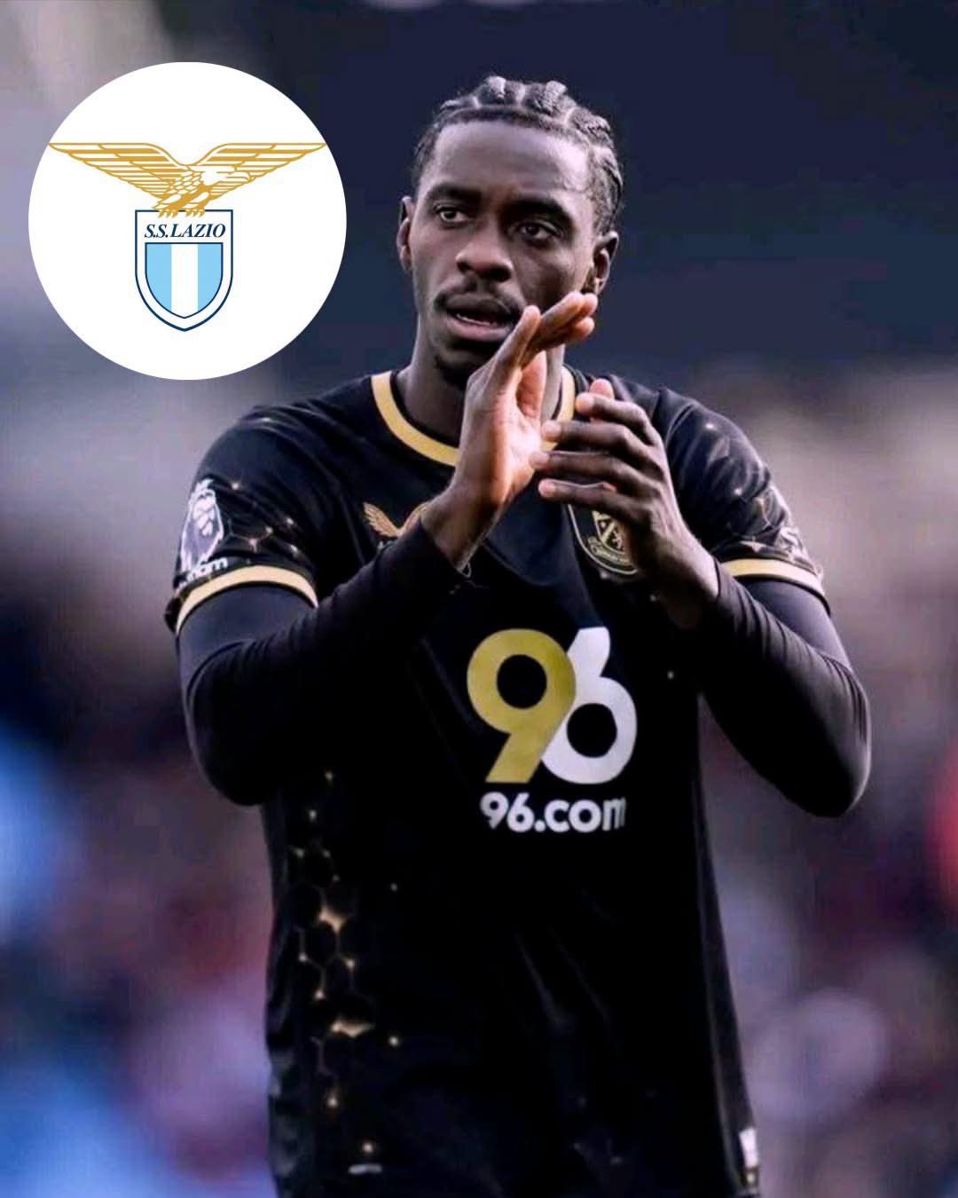 Footballer in a black kit clapping on the field, sponsor 96.com visible on the chest.