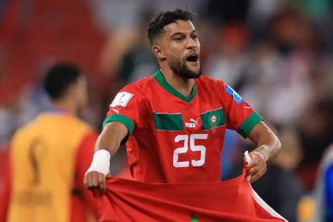 Morocco soccer player wearing red jersey with number 25 celebrating on the field.