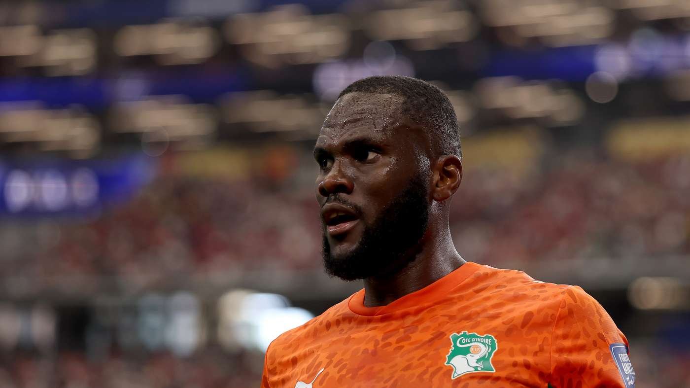 Ivory Coast footballer with a beard in an orange jersey on the pitch during a match.