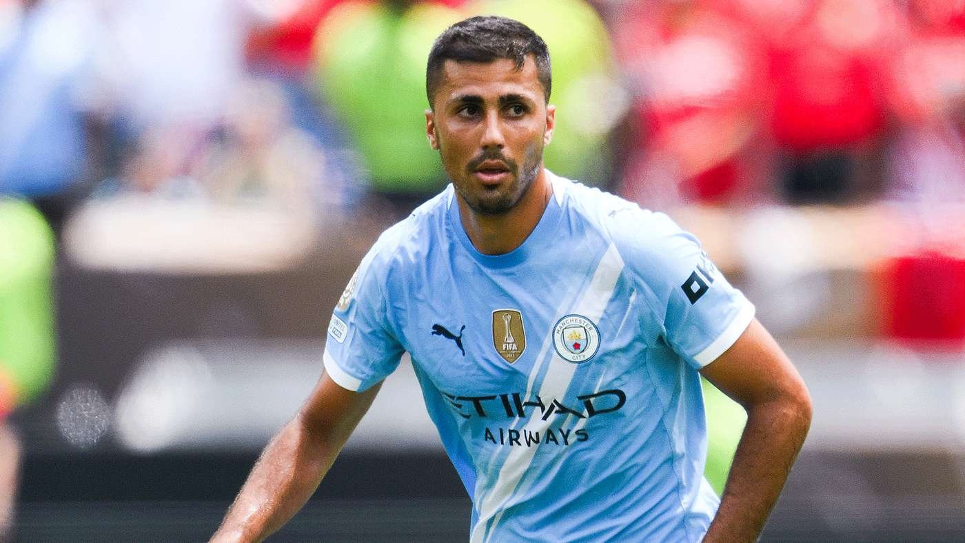 Manchester City footballer in a light blue jersey running on the pitch during a match