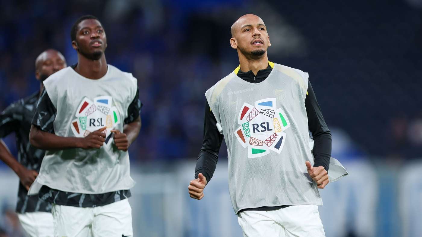Two soccer players in light practice bibs jogging on a field, RSL logo on their vests