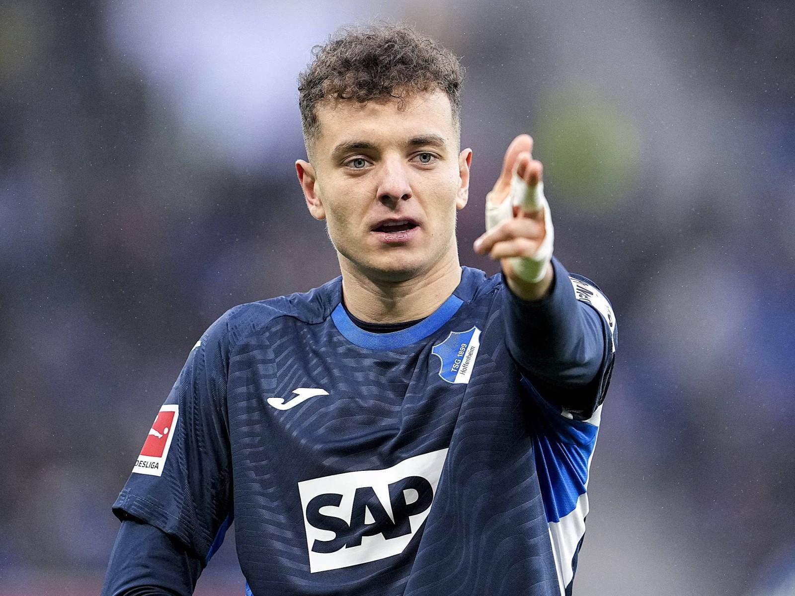 Soccer player in a blue jersey with SAP logo pointing forward during a match.