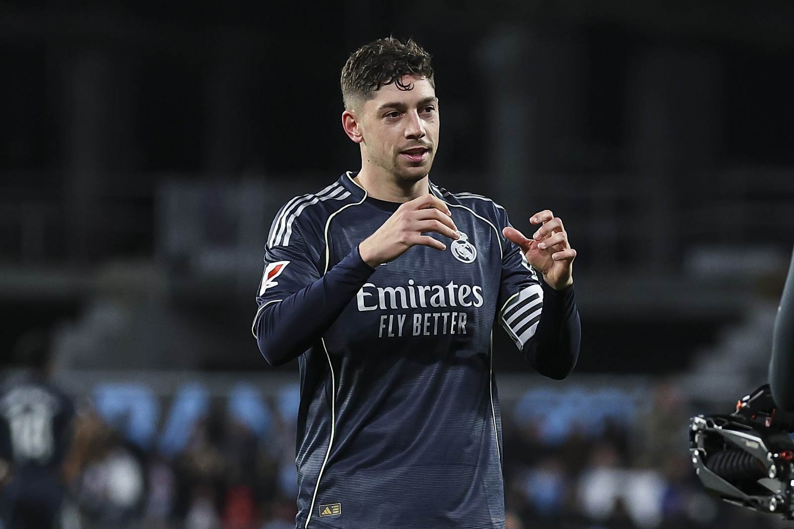 Soccer player in Real Madrid jersey gesturing on the field during a match