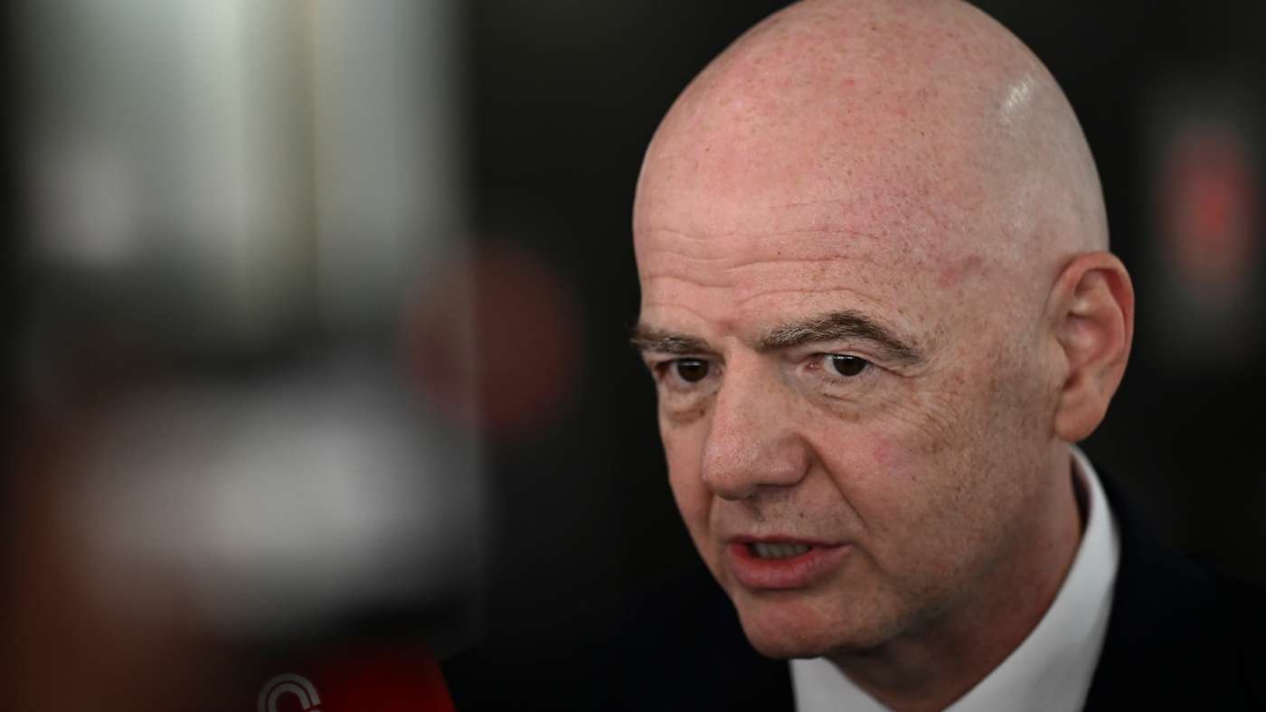 Close-up portrait of a bald, middle-aged man in a dark suit speaking during an interview, with a blurred background. Close-up portrait of a bald, middle-aged man in a dark suit speaking during an interview, with a blurred background.
