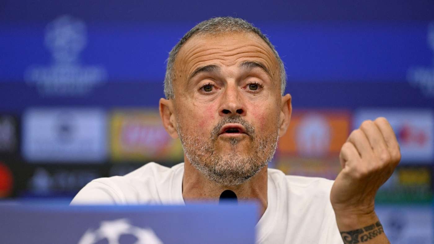 Man with short gray beard speaks at a press conference, gesturing with his right hand toward the microphone in front of him. Man with short gray beard speaks at a press conference, gesturing with his right hand toward the microphone in front of him.